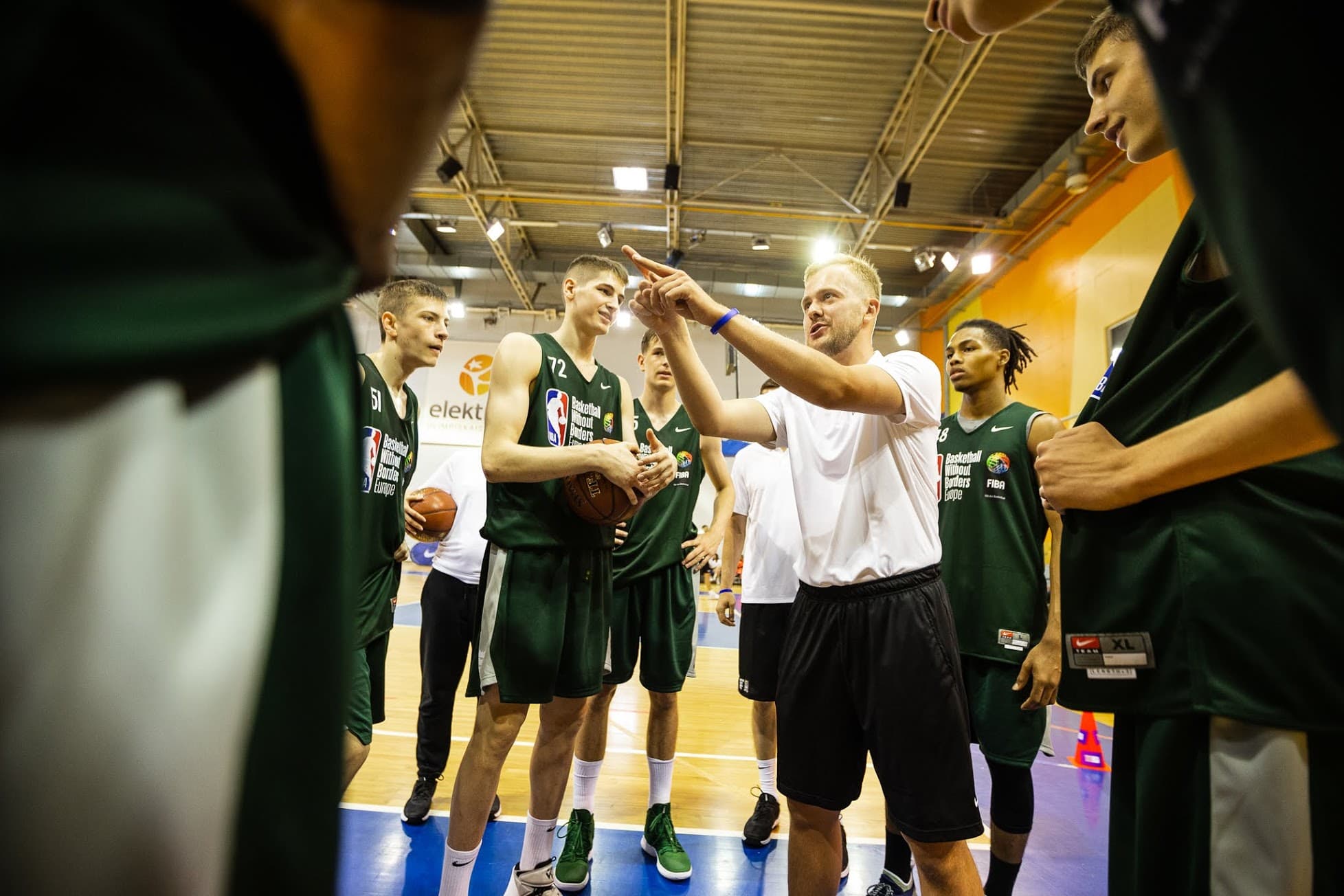Alex Sarama coaching players in a Basketball Without Borders Europe team huddle