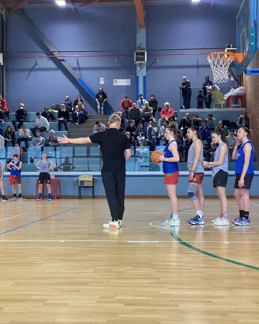 Alex Sarama leading an on-court demonstration at a basketball coaching clinic