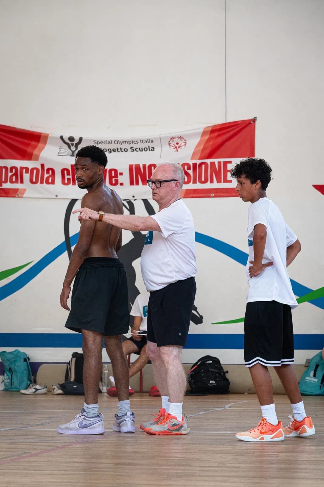 A coach demonstrating a movement to players during an indoor camp session