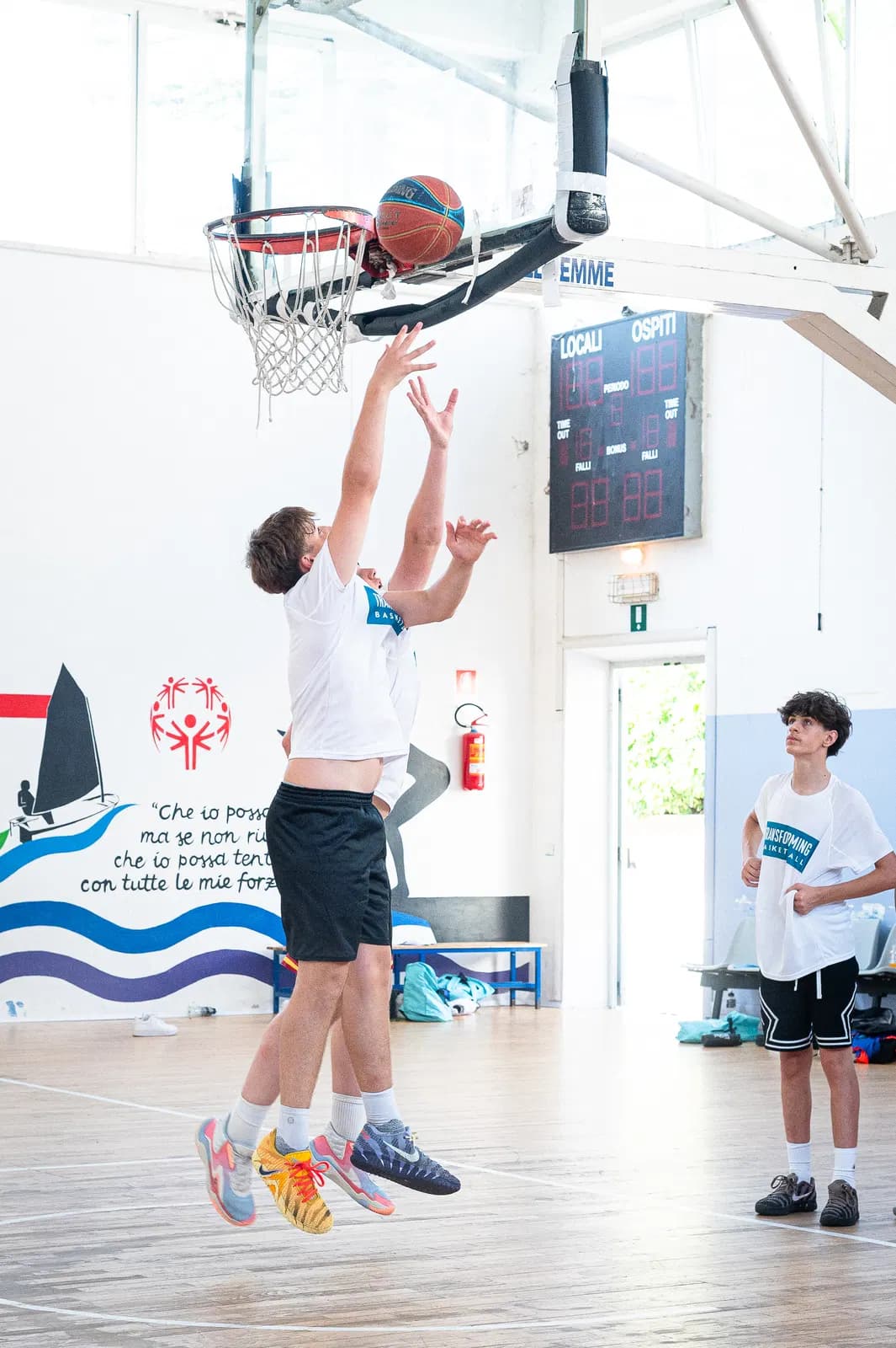 A player leaping for a rebound during an indoor camp session