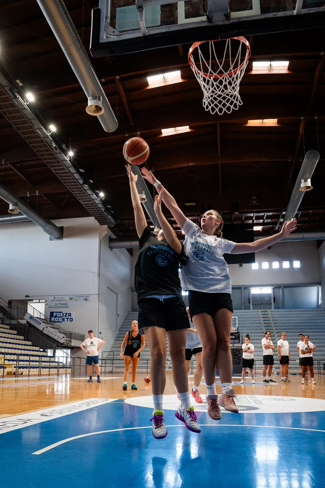 A player adapts a finish beside a defender at Roseto camp