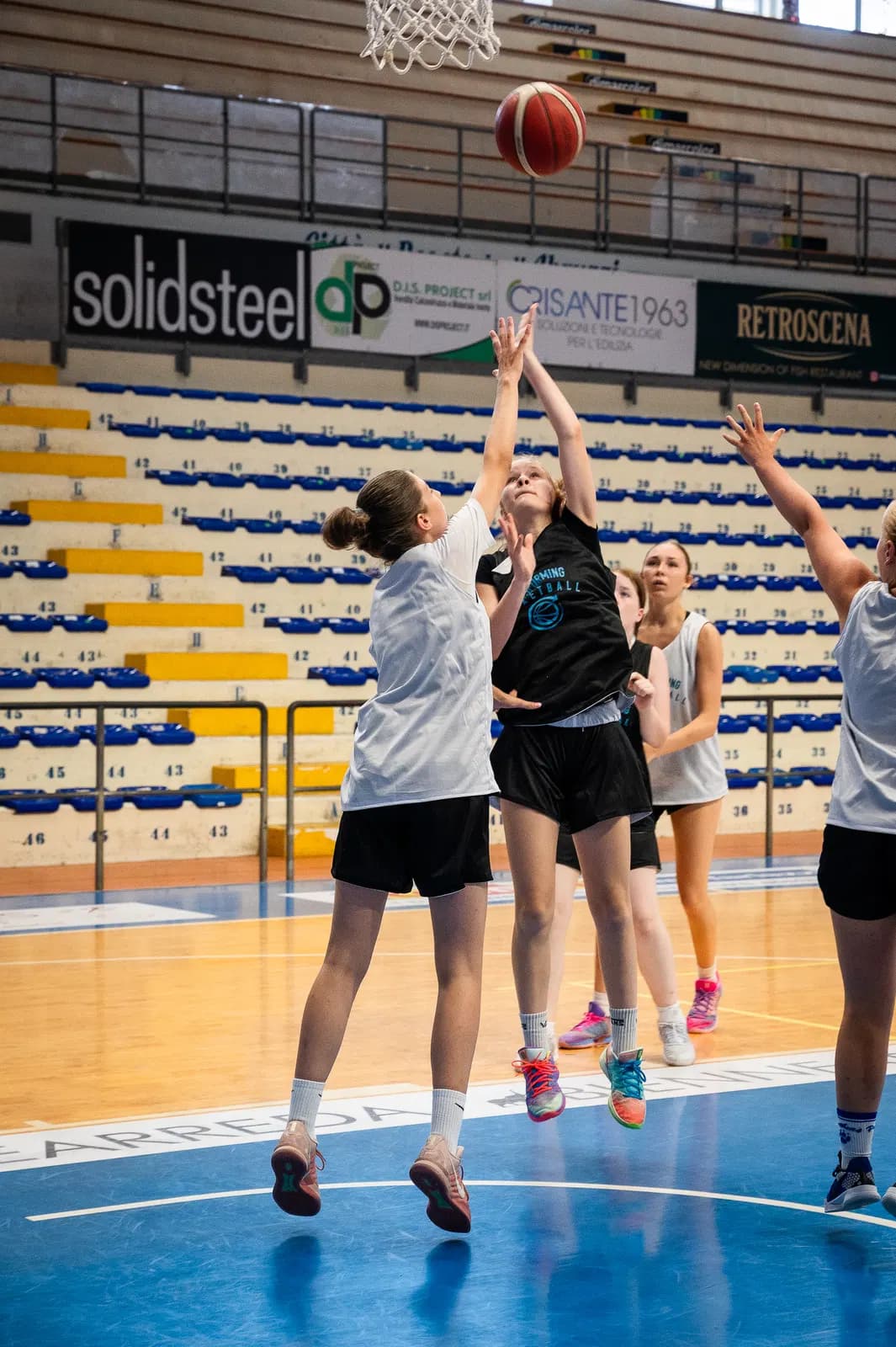 An offensive player releases a shot with defenders contesting at Roseto camp