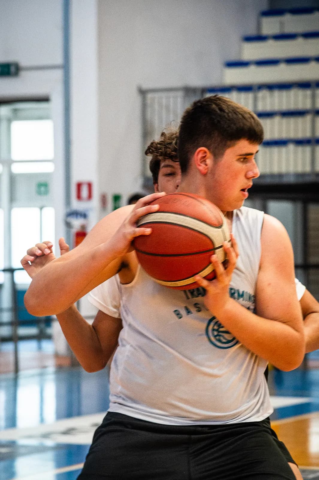 A teenage player protecting the ball from a defender at the Transforming Basketball camp in Roseto