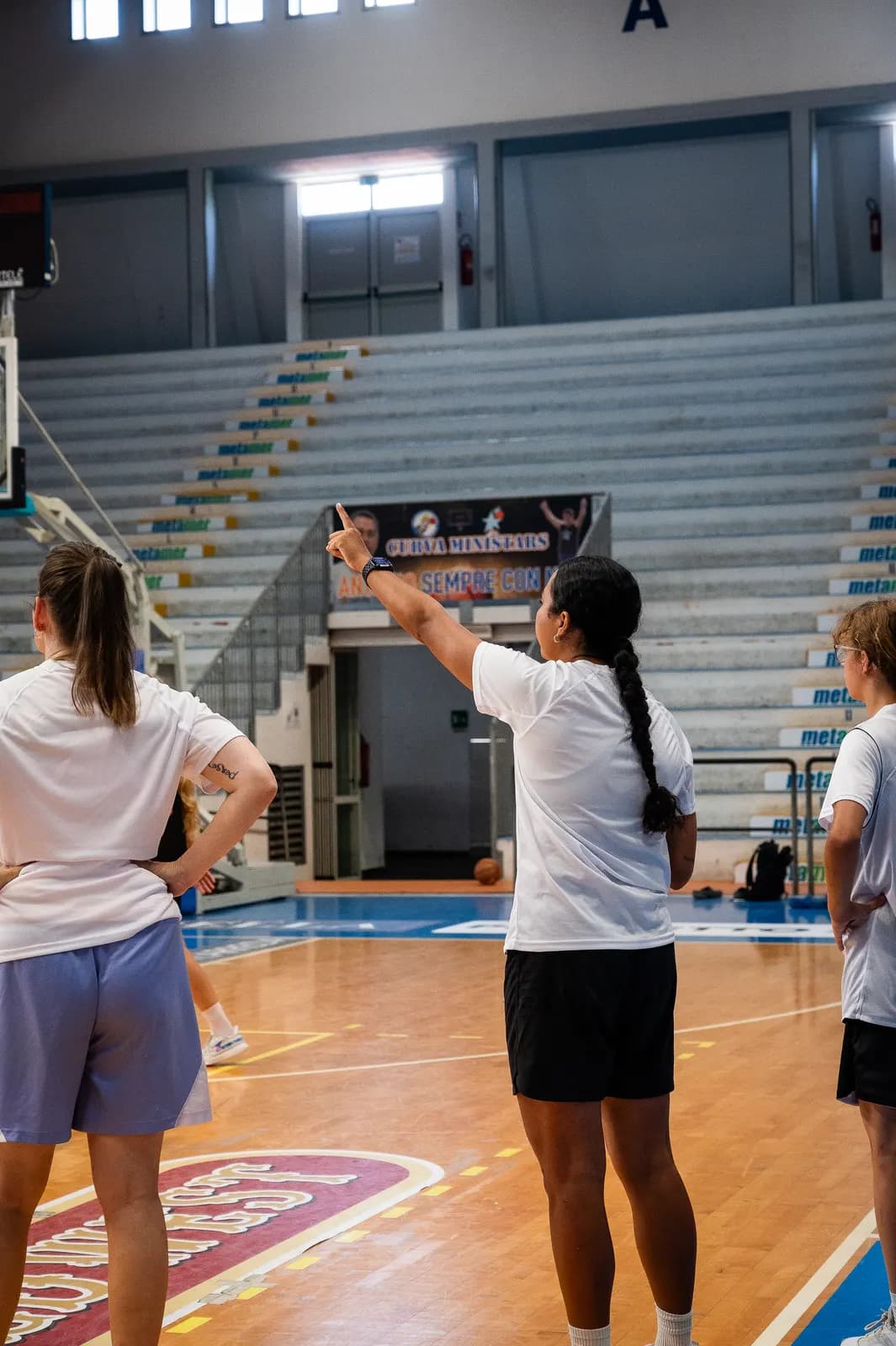 A coach giving a short instruction to a group of young players at the 2026 Transforming Basketball camp in Roseto