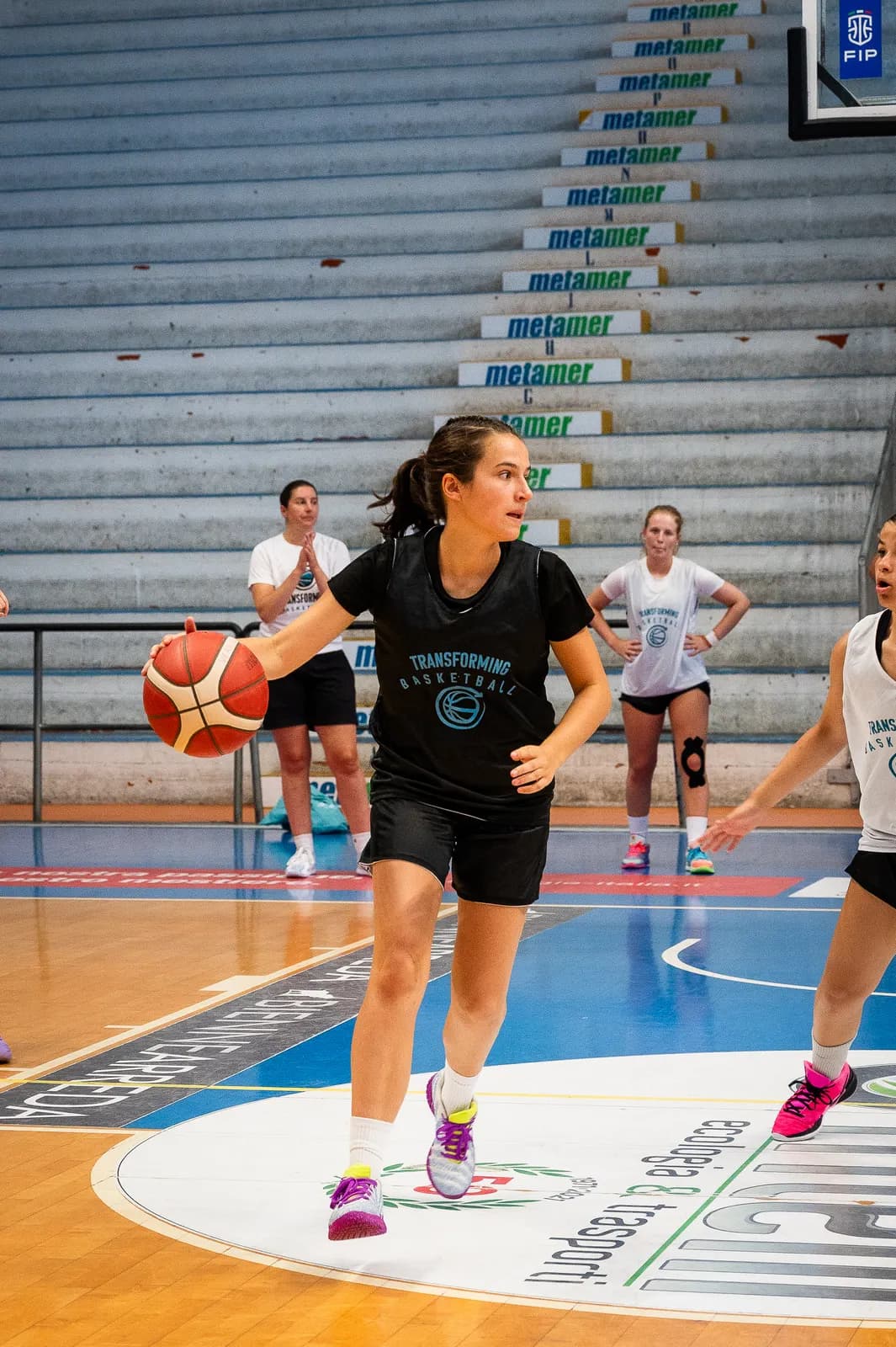 A young player dribbling up the court during a girls game at the Transforming Basketball camp in Roseto