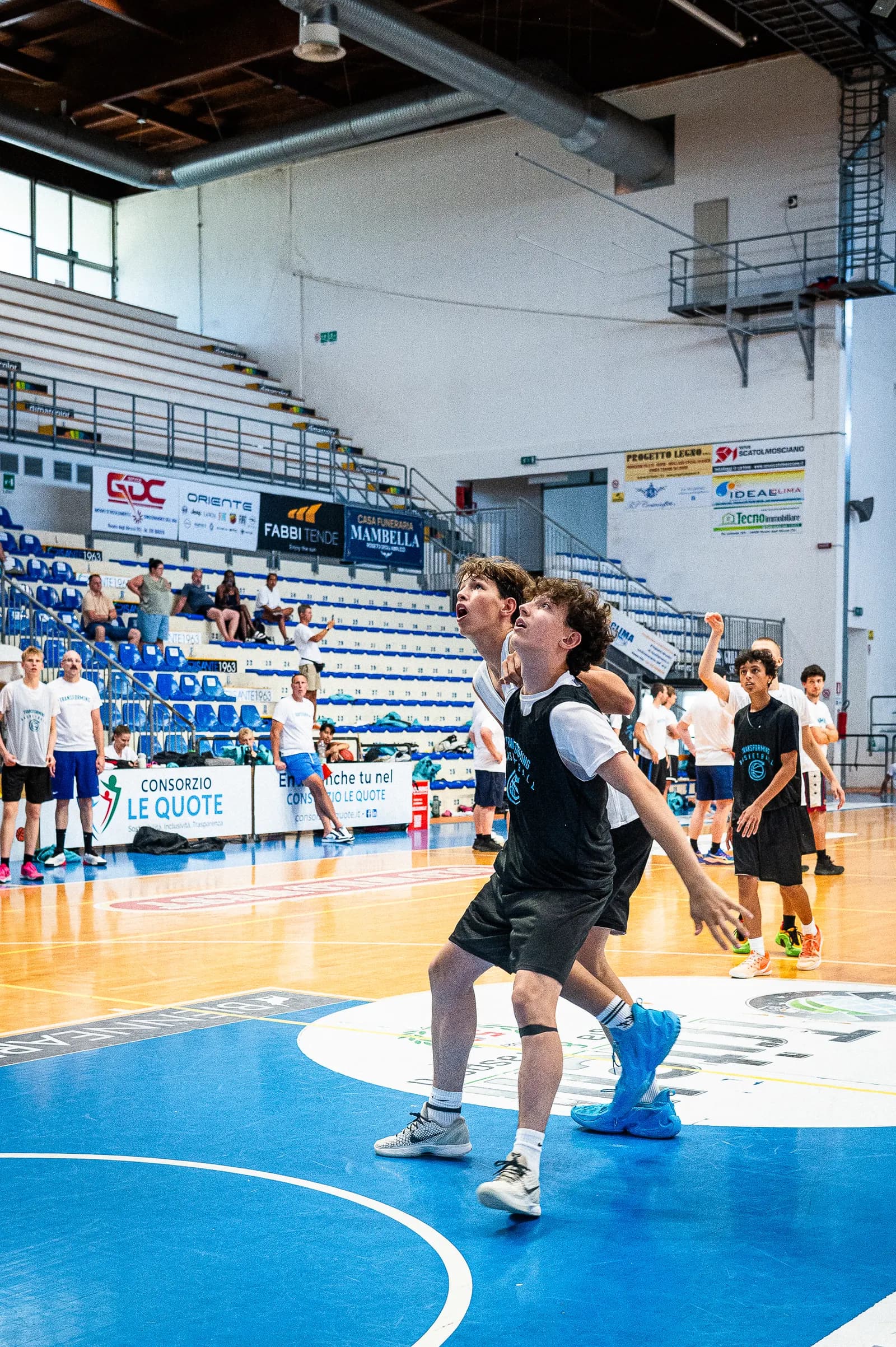 Two players boxing out and watching the ball for a rebound at the Transforming Basketball camp in Roseto