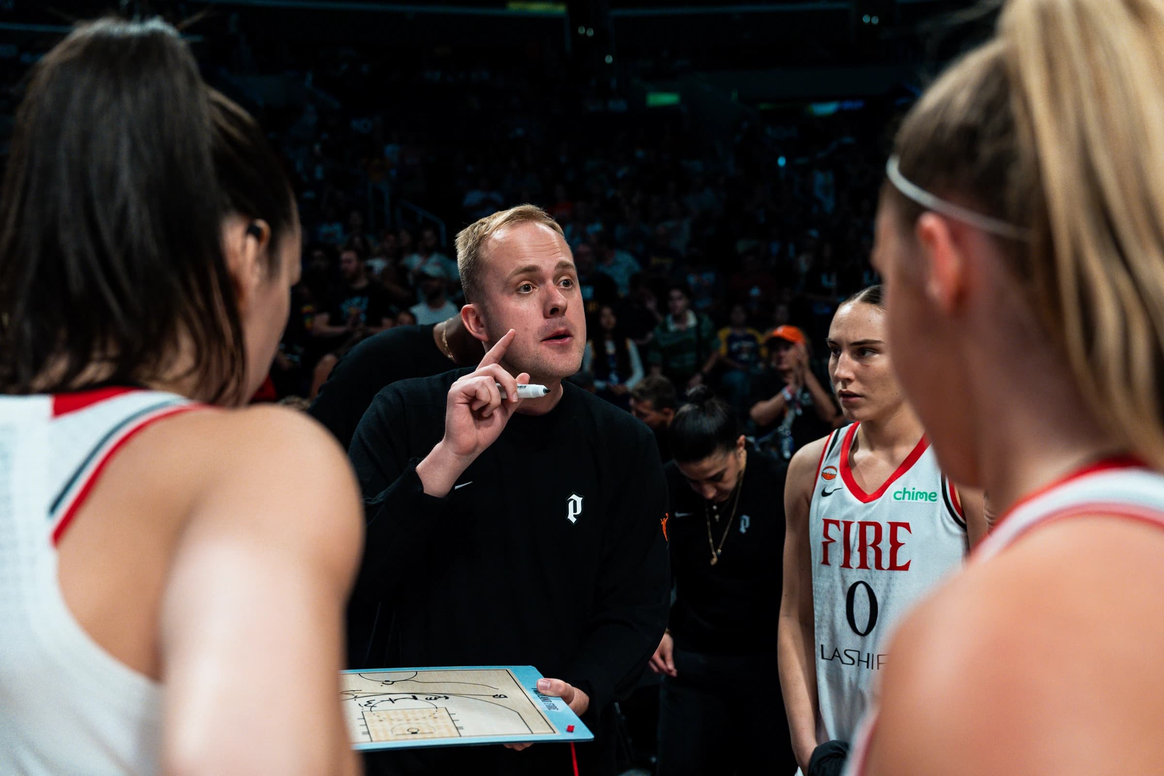 Alex Sarama coaching a Portland Fire timeout huddle.