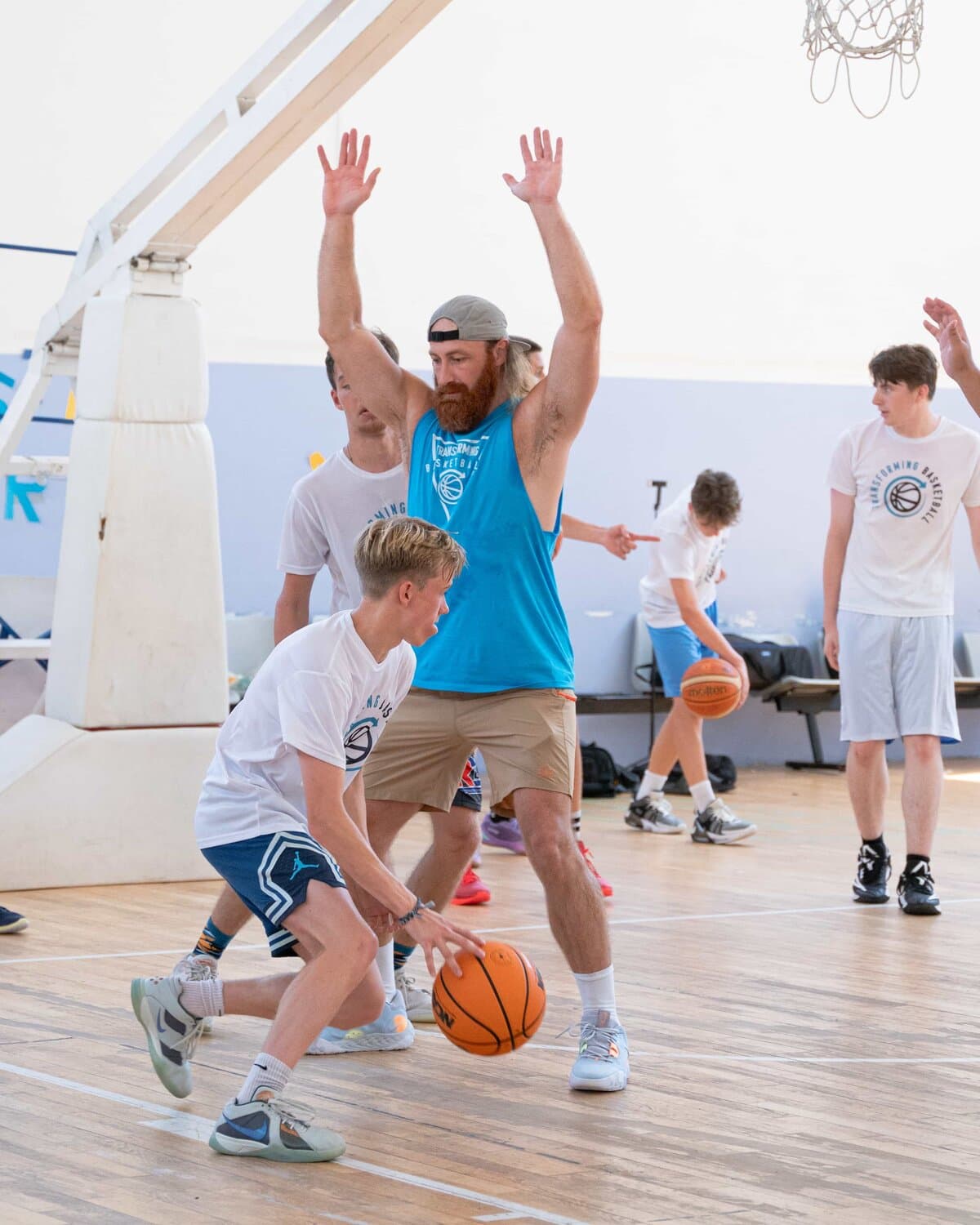 A young player dribbles against a Transforming Basketball coach during a youth session